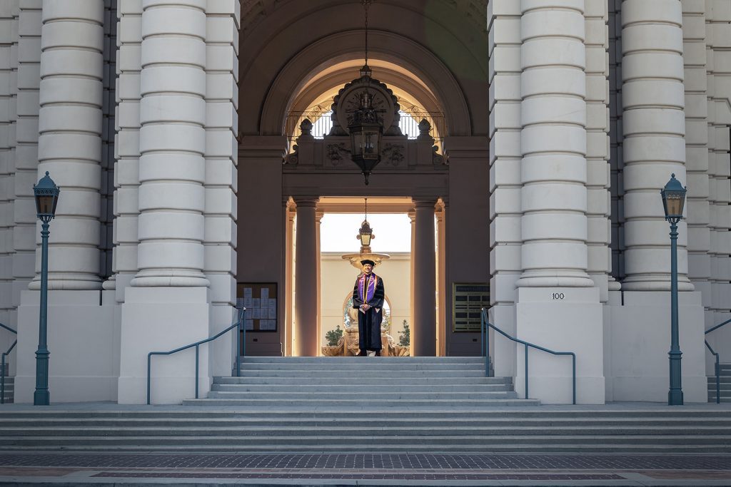 A man standing on the steps of a building, captured by wedding photographer Thomas Kim.