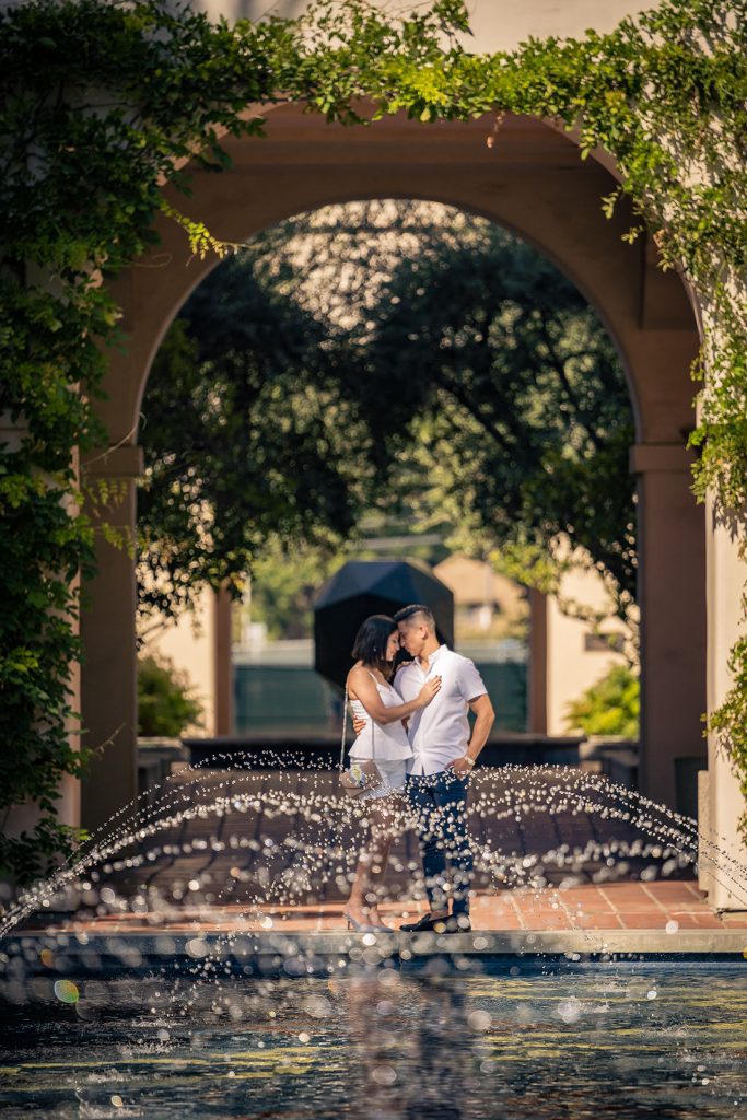 A wedding couple posing in front of a Los Angeles fountain, captured by a photographer.