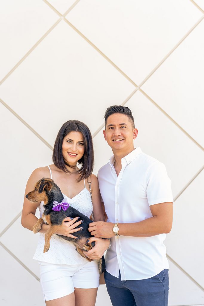 Photographer Thomas Kim captures a man and woman with their dog in front of a white wall in Los Angeles.
