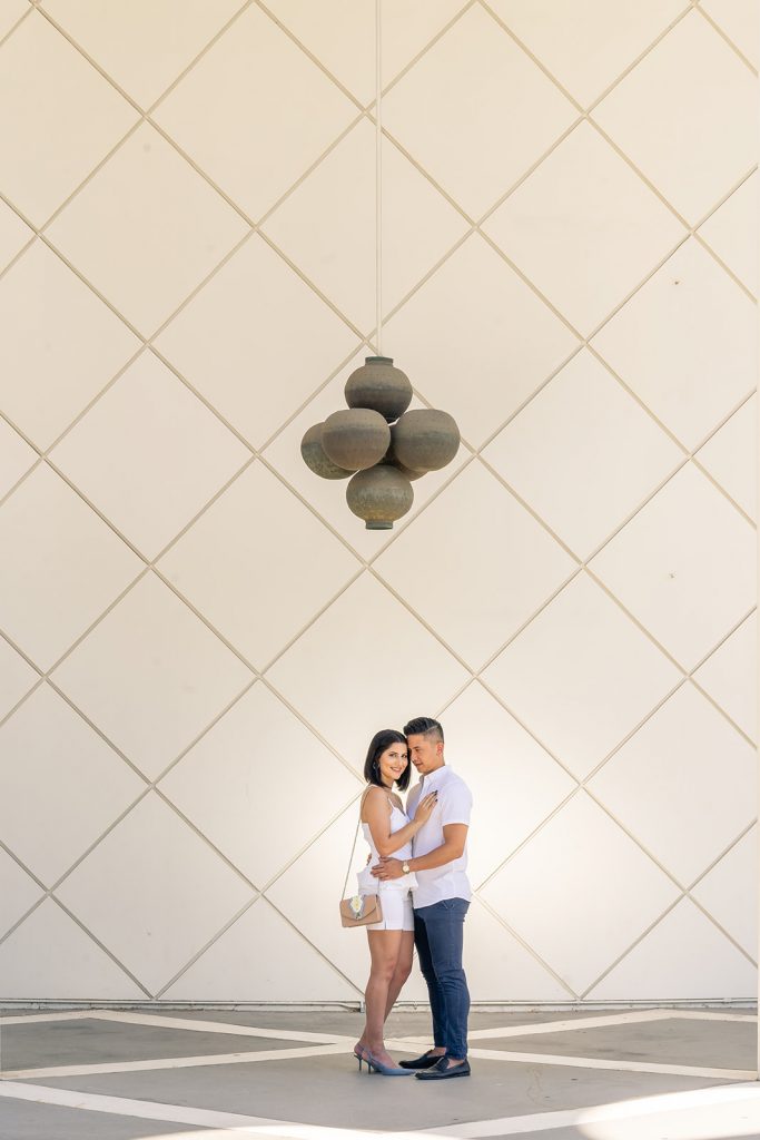 A couple posing in front of a white wall for their Los Angeles wedding.
