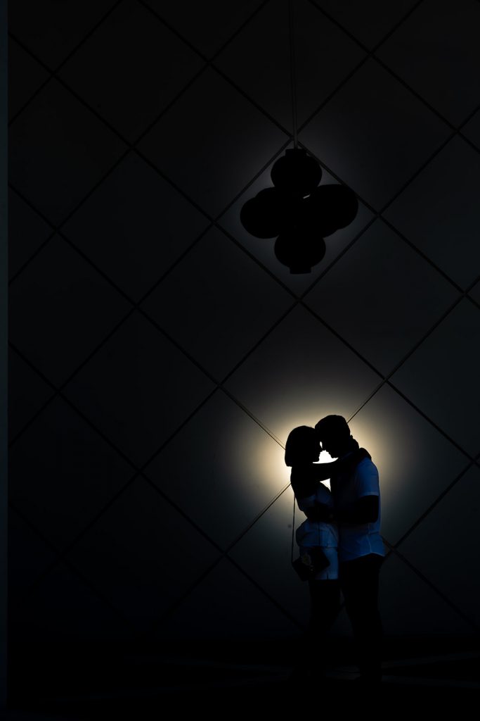 Thomas Kim, a wedding photographer, captures a stunning silhouette of a couple kissing in front of a light.