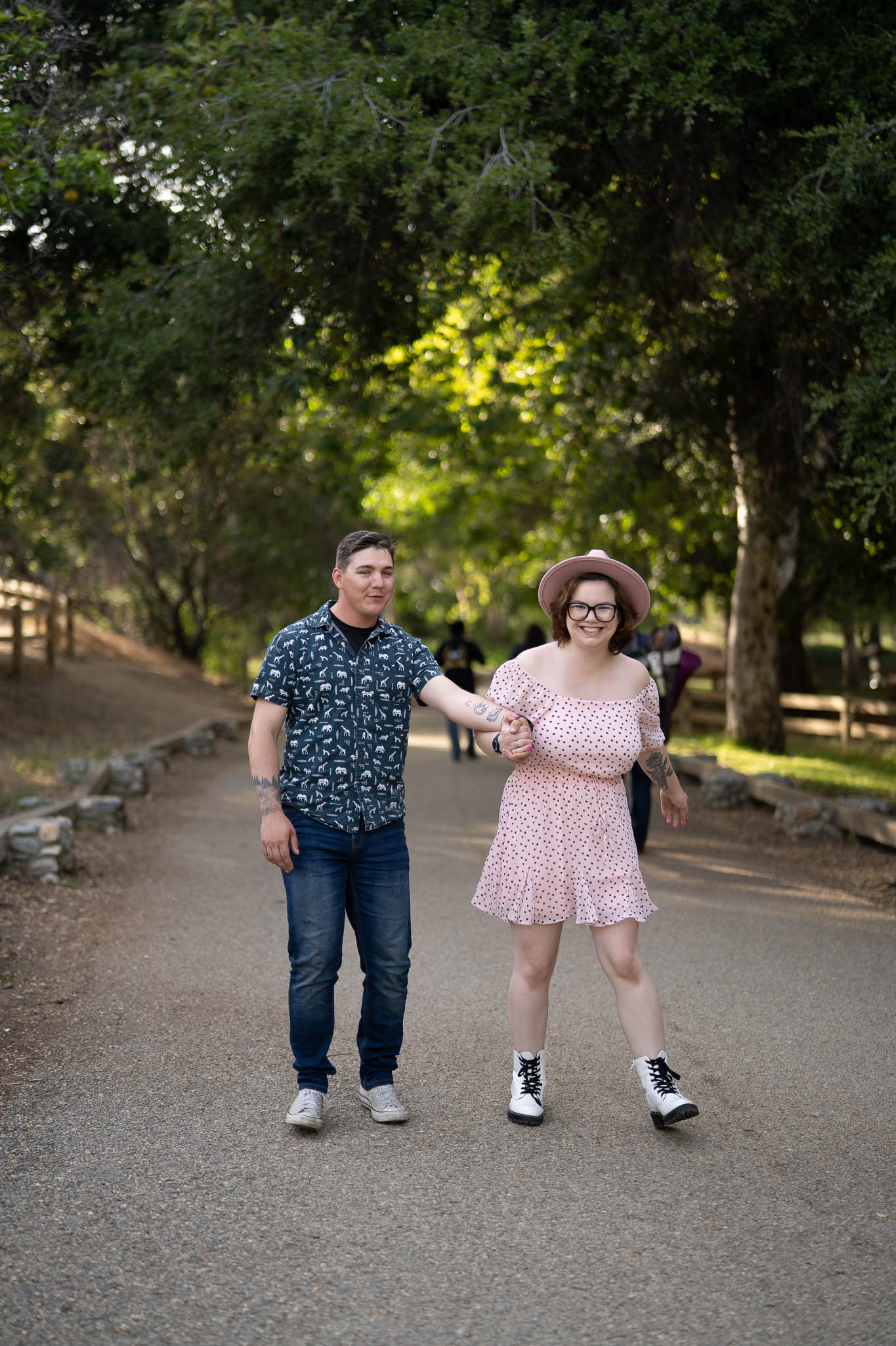 ThomasKim_photography K and S's engagement session, with a couple walking down a path in a park.