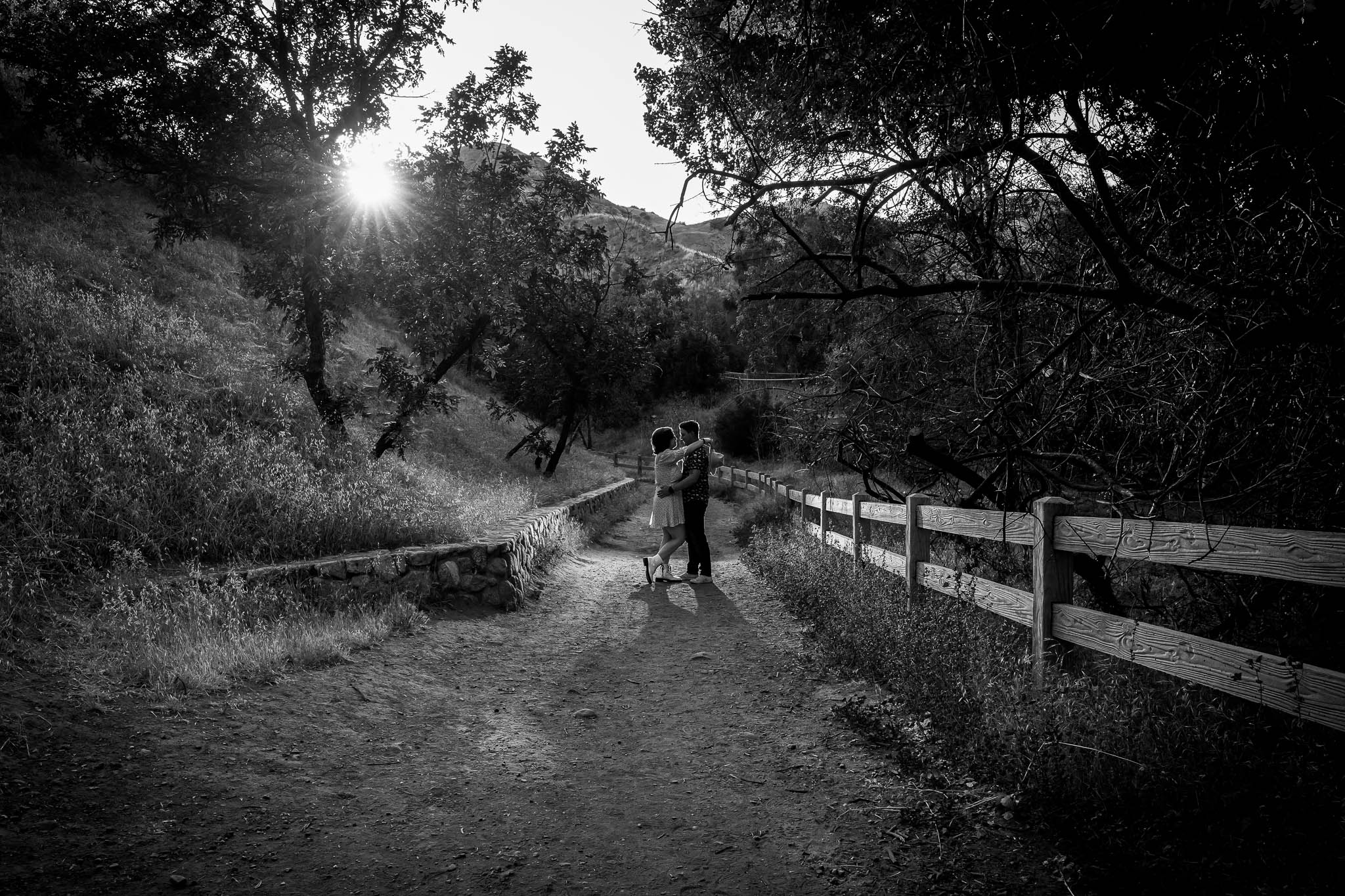 A black and white photo of a couple walking down a path, captured by a Los Angeles photographer.