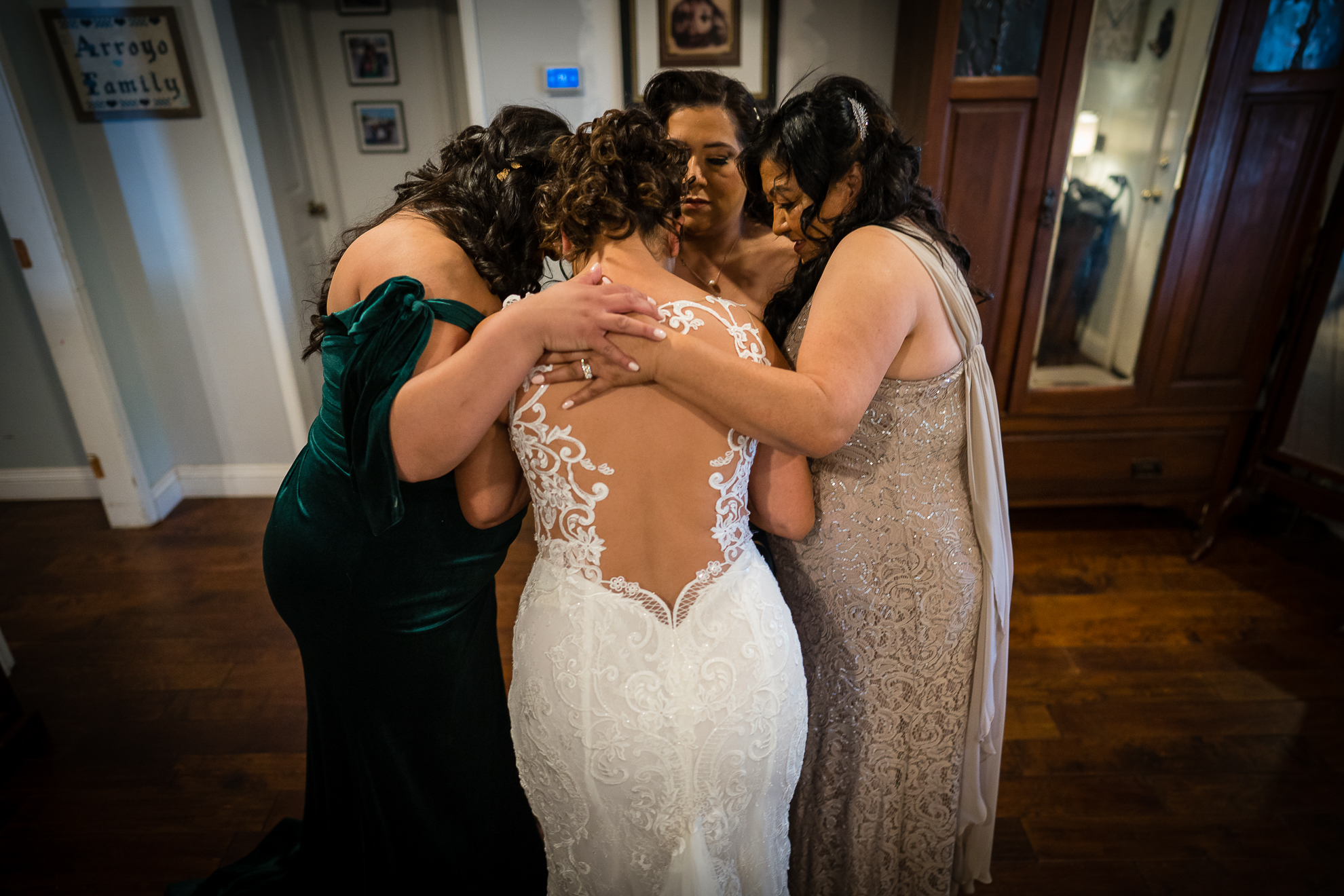 ThomasKim_photography A bride and her bridesmaids in front of a mirror at the wedding venue.