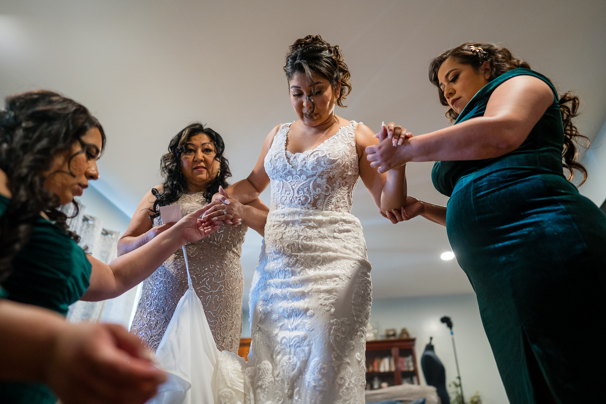 ThomasKim_photography A group of bridesmaids helping each other put on their wedding dresses while S&A.