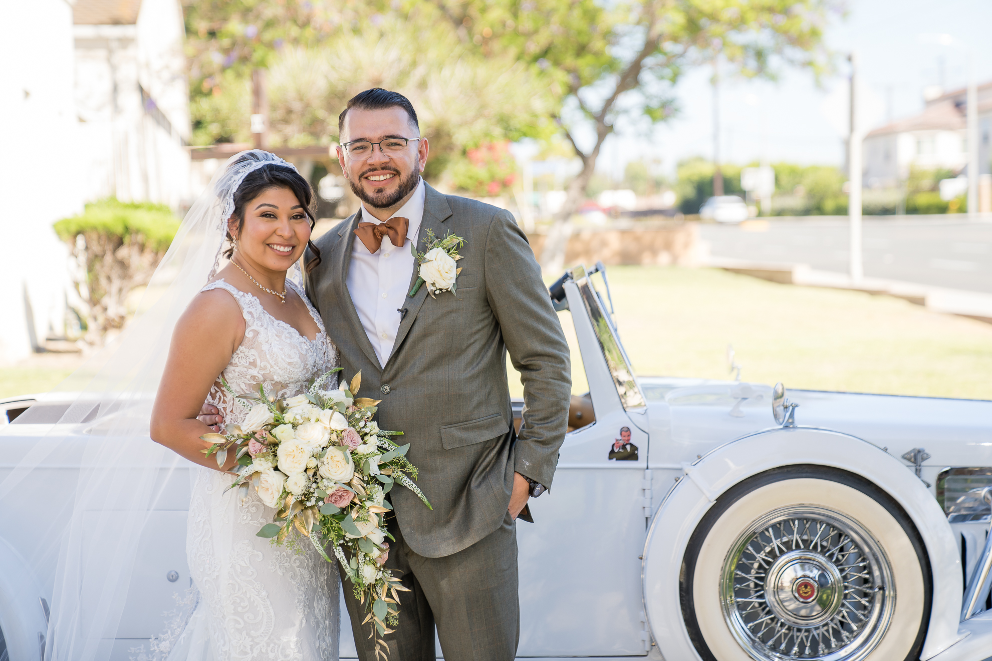 ThomasKim_photography A bride and groom standing next to an antique car at their S & A themed wedding.