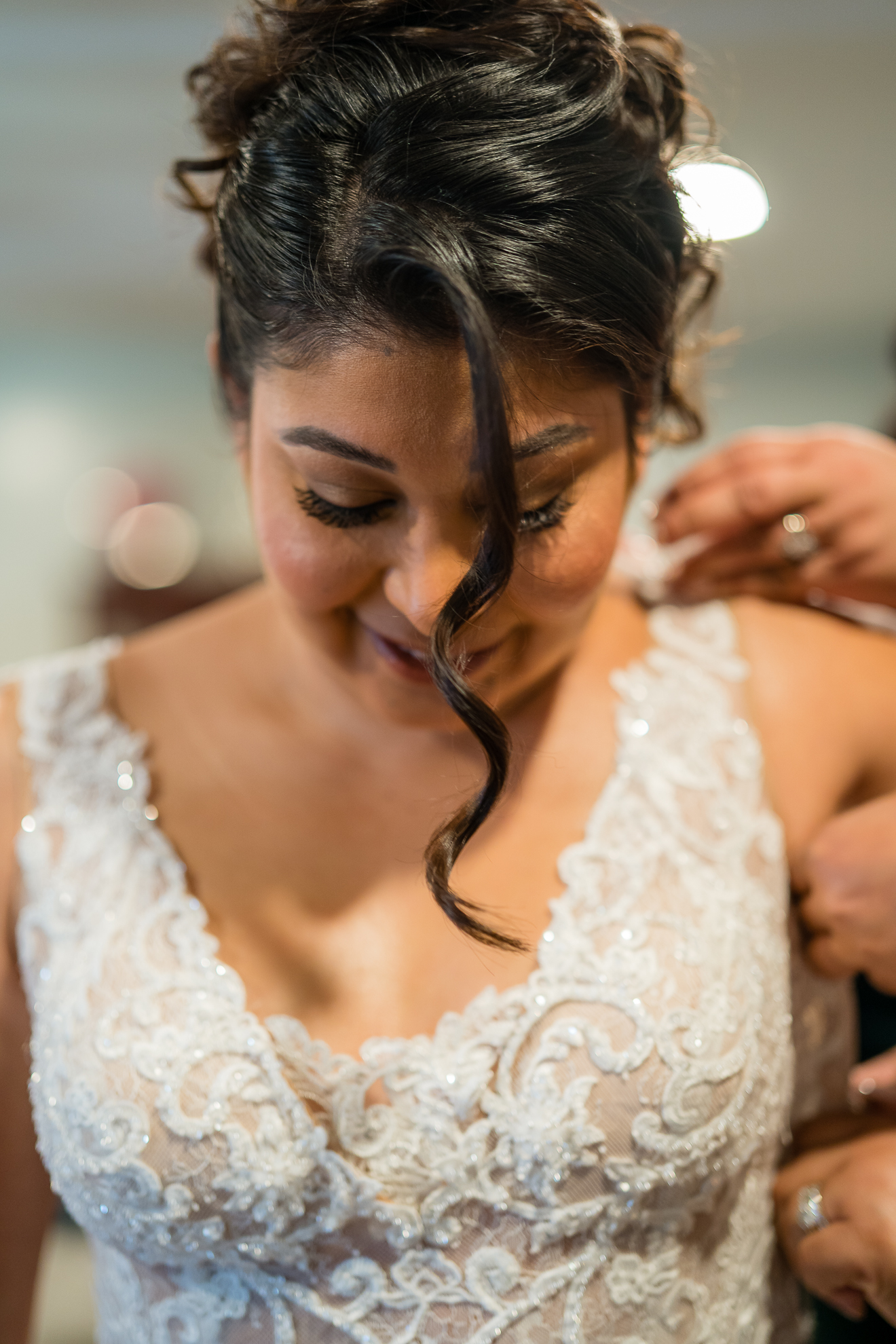 ThomasKim_photography A bride gracefully putting on her stunning wedding dress.