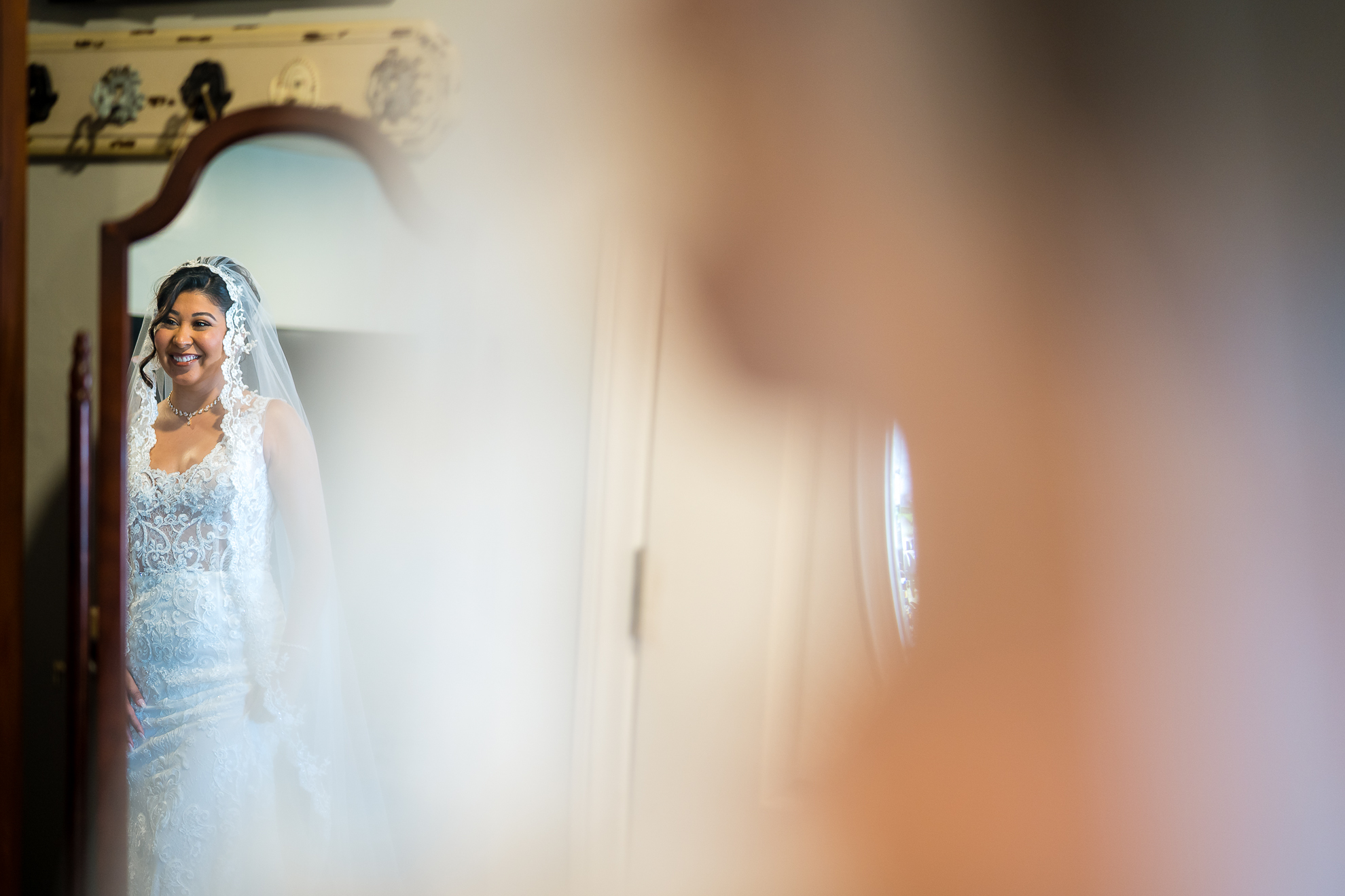 ThomasKim_photography A bride in a wedding dress admiring herself in front of a mirror.