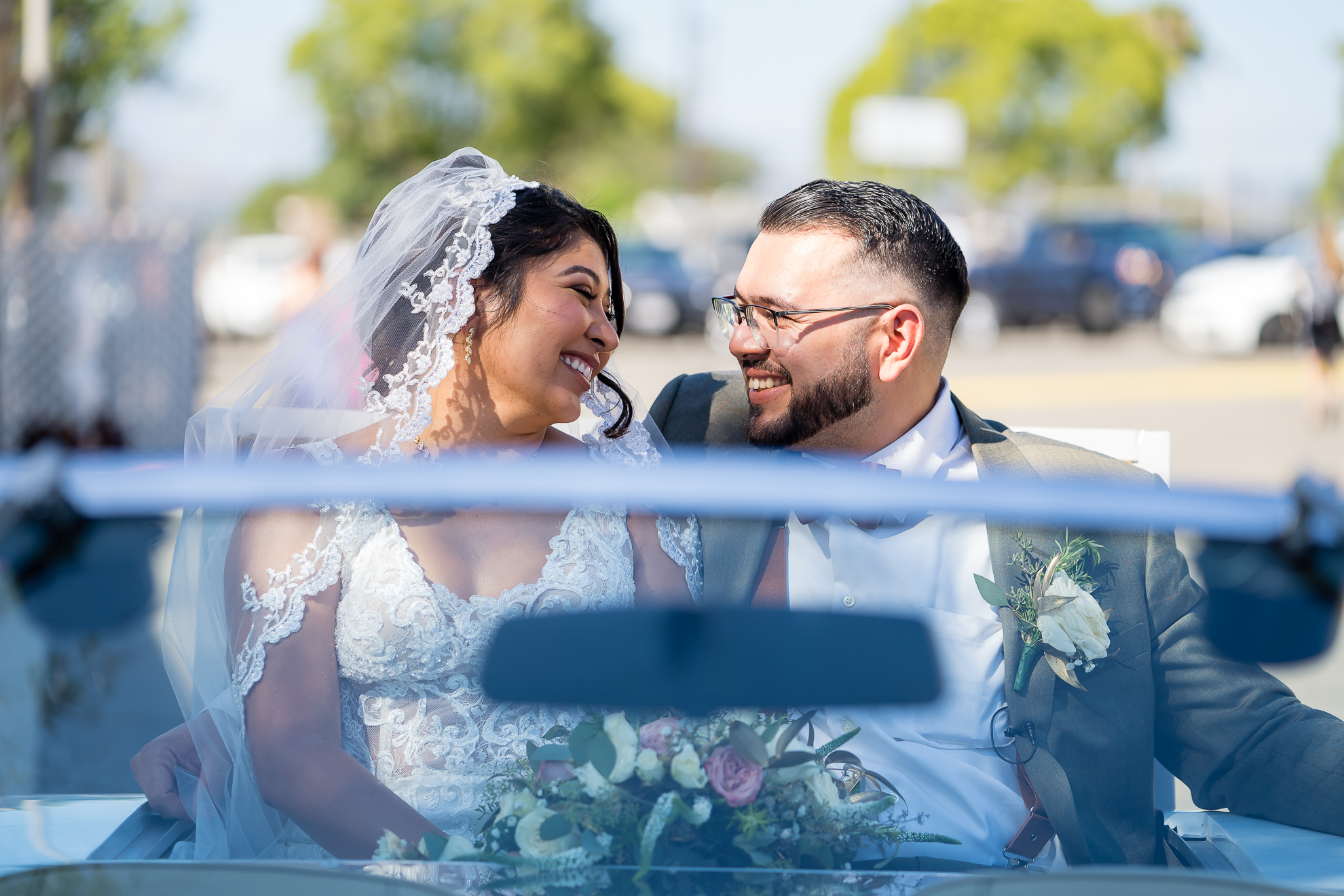 ThomasKim_photography A bride and groom, S & A, smiling in a convertible car.