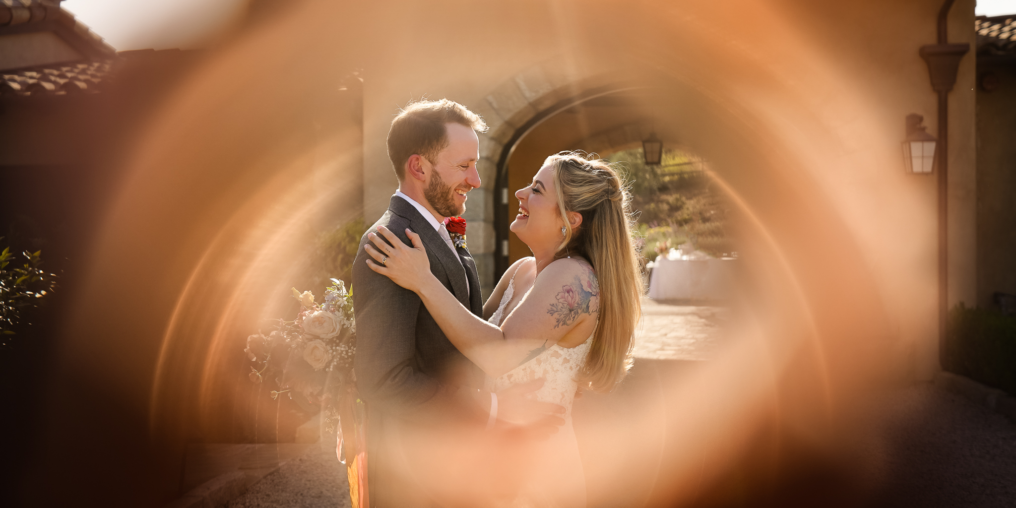 ThomasKim_photography A professional wedding photographer captures the emotional embrace of a bride and groom in front of a circular window.